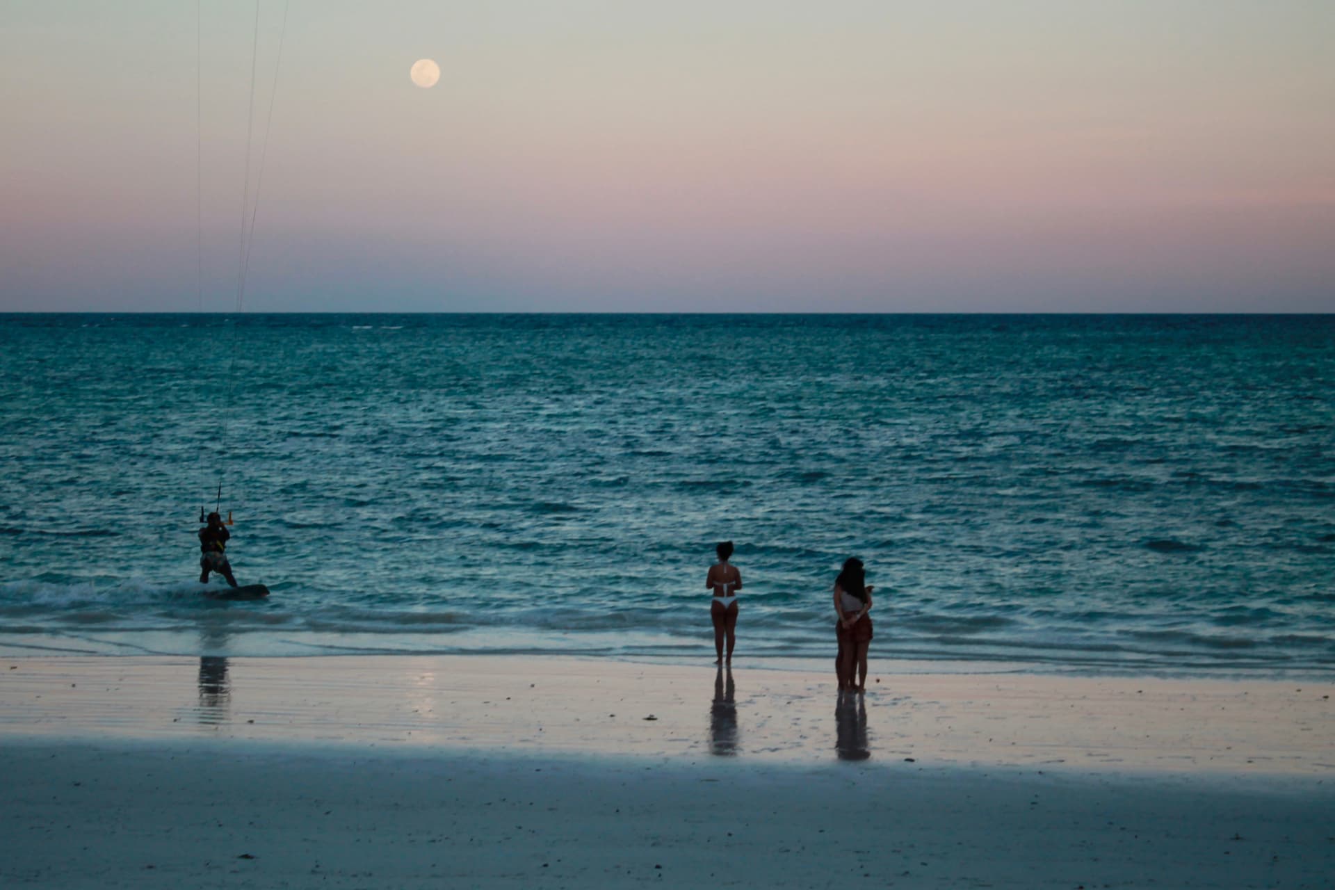 Atardecer en la playa con la luna llena sobre el mar